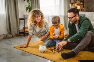 Family saving money together in a piggy bank.