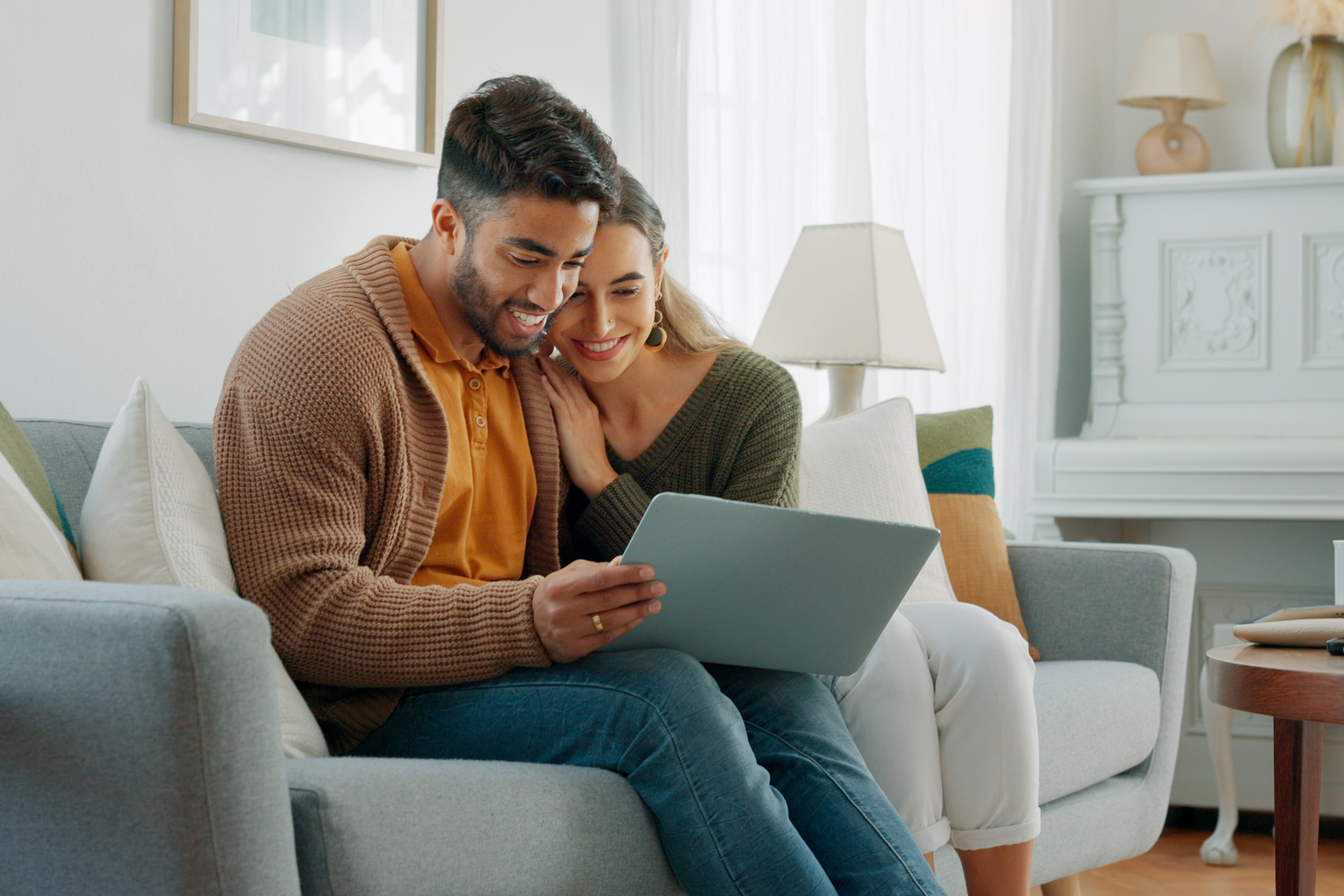 Couple sitting on couch talking to a Rave Financial representative on their laptop