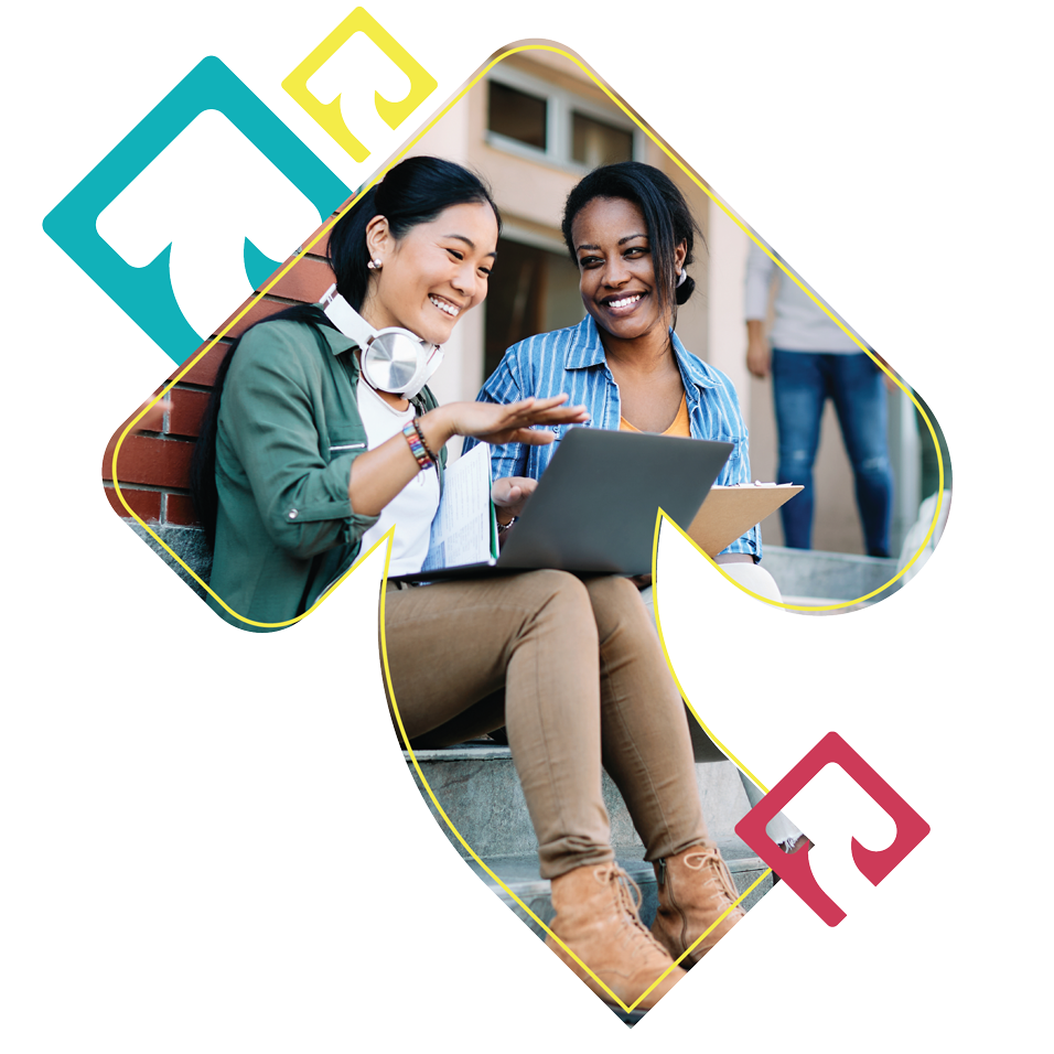 Two female college students talking together looking at computer