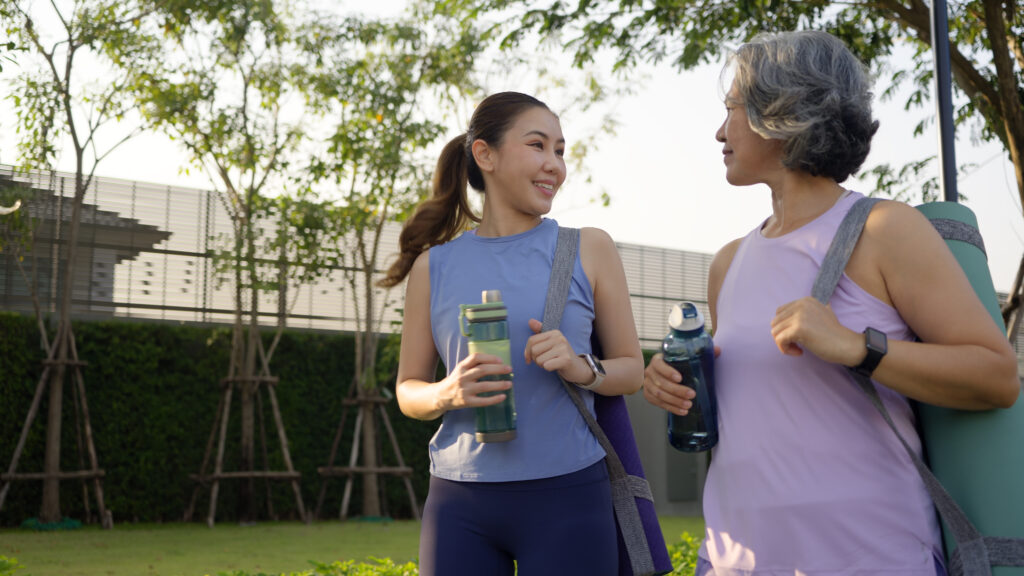 Young woman walking next to aging woman having conversation
