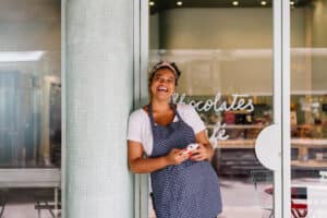 female business owner standing in front of cafe door